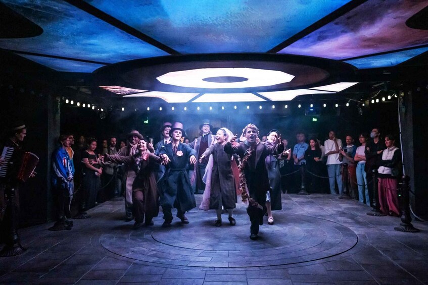 A group performing on a stage with a circular design and a large illuminated sign above. 5