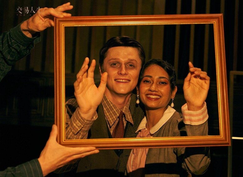 A person holding a framed photo with another individual inside it. 2