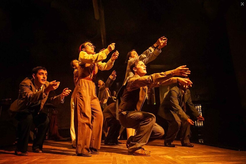 A group of people in a theatrical performance on a stage. 1