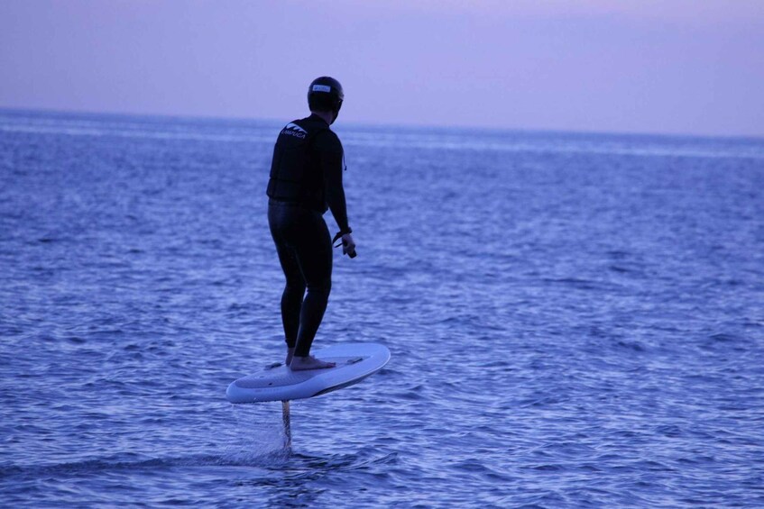 A person surfing on a wave in the ocean. 4