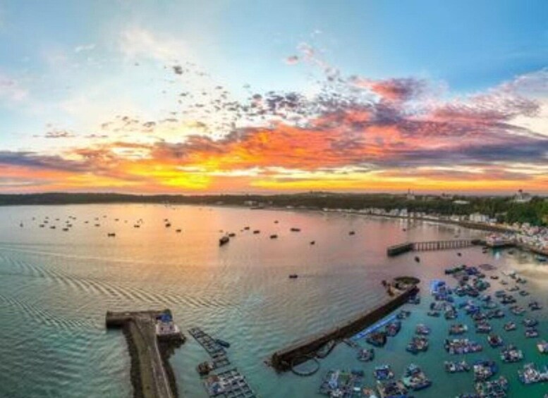 A sunset over a harbor with boats and a pier. 5