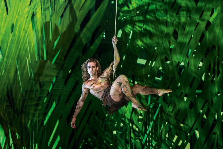 A person swinging through dense green foliage. 3