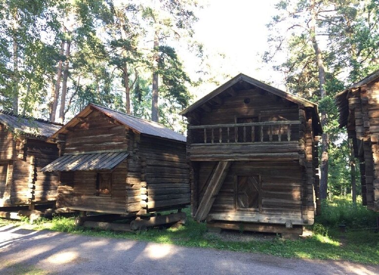 A row of rustic log cabins in a forested area. 2