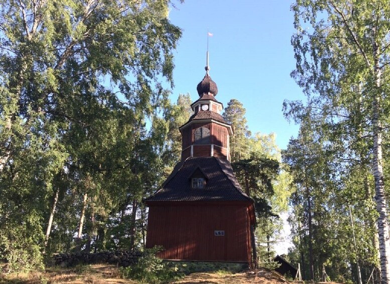 A wooden church with a bell tower surrounded by trees. 5