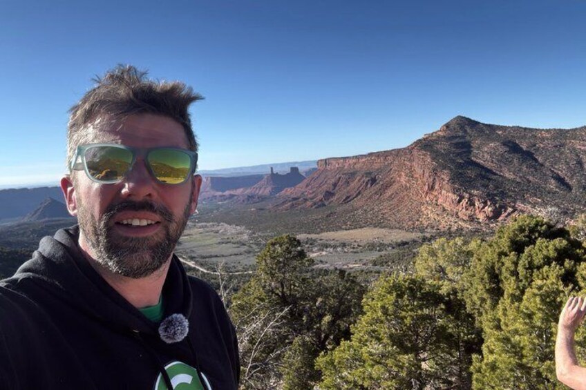 A person standing with a mountainous landscape in the background. 2