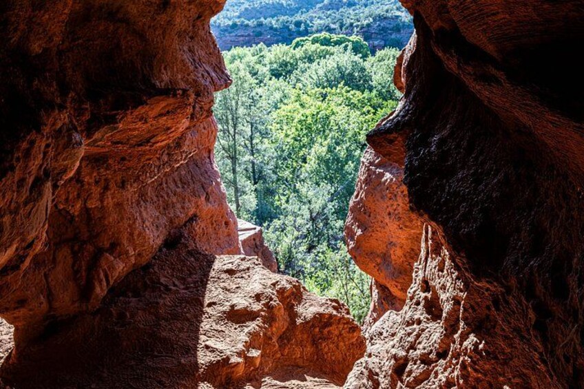 A canyon with red rock formations and a view of a forested valley. 3