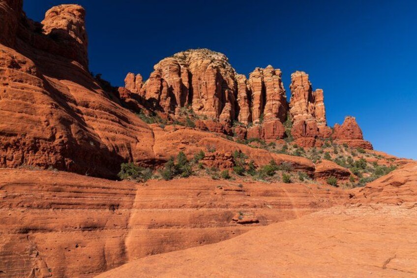 A desert landscape with red rock formations and sparse vegetation. 2