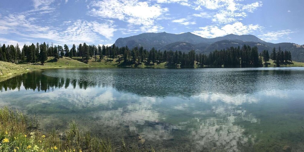 A clear lake surrounded by mountains and trees. 2