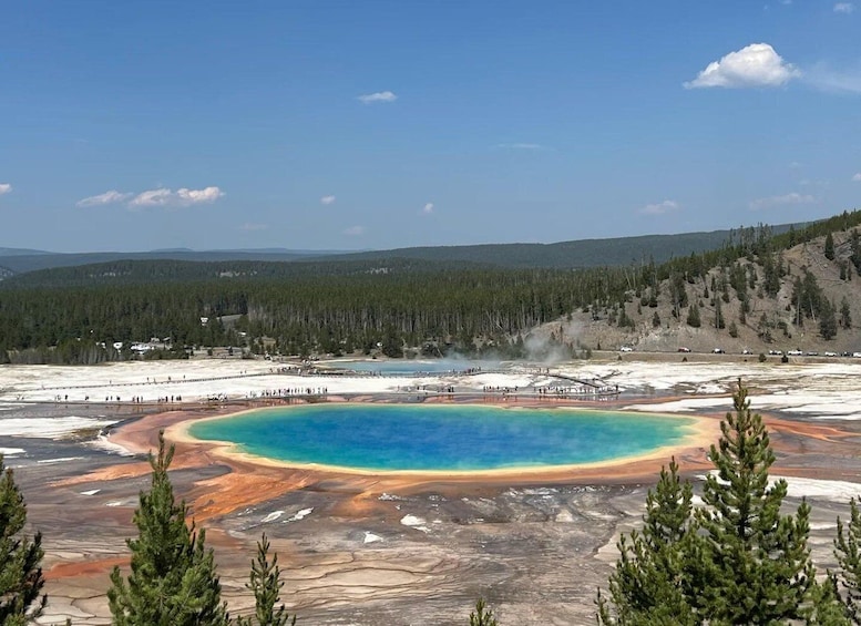 A geothermal hot spring with a turquoise center surrounded by mineral deposits. 1