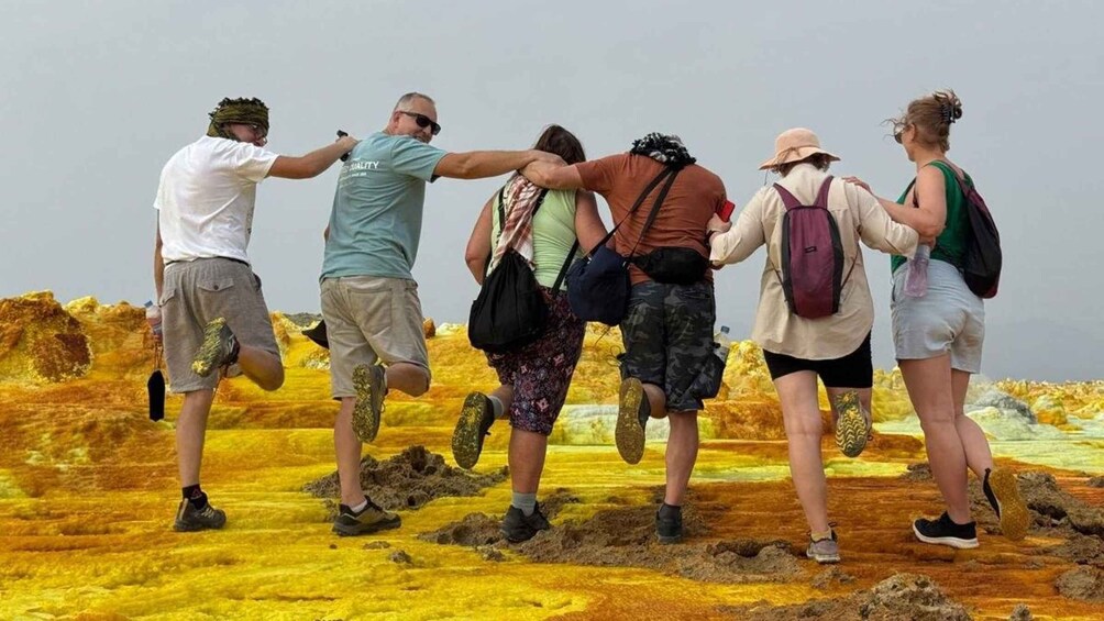 A group of people hiking on a colorful, rocky terrain. 1