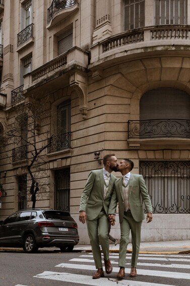 Two men in suits walking on a street with a classic building in the background. 4