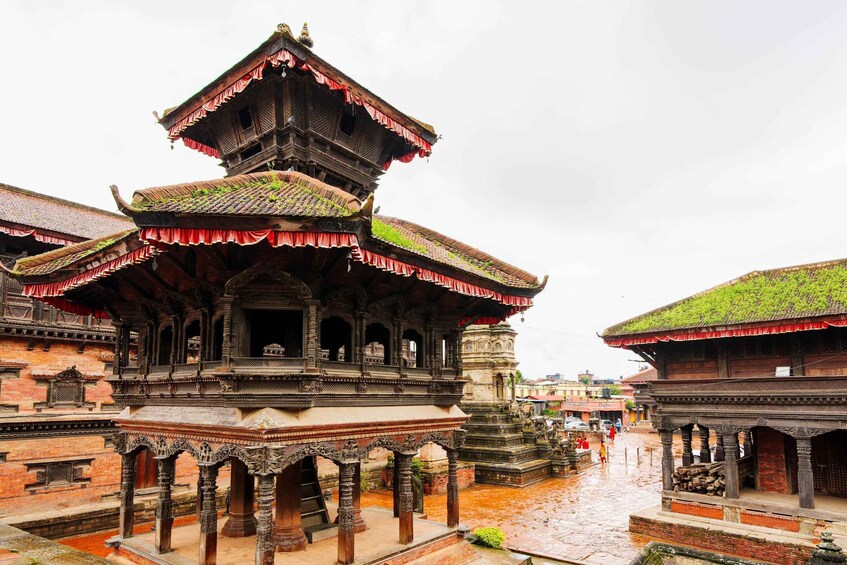 A traditional multi-tiered temple with intricate carvings and a red-tiled roof. 4