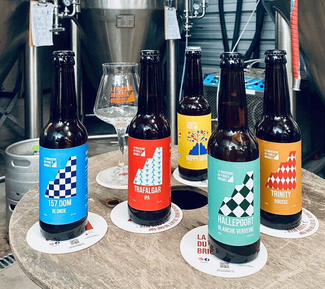 Bottles of beer with distinct labels and a glass of beer on a table. 1