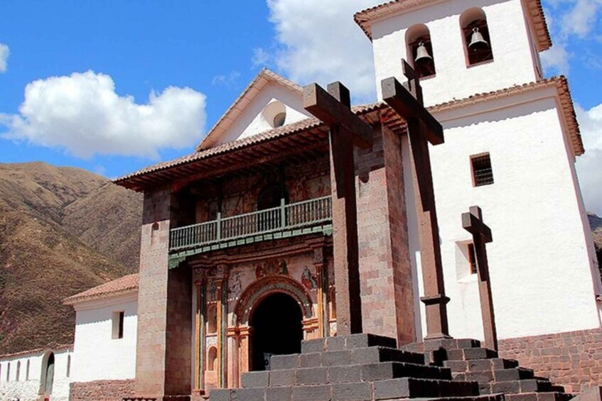 A church with a bell tower, a balcony, and a mountain in the background. 5