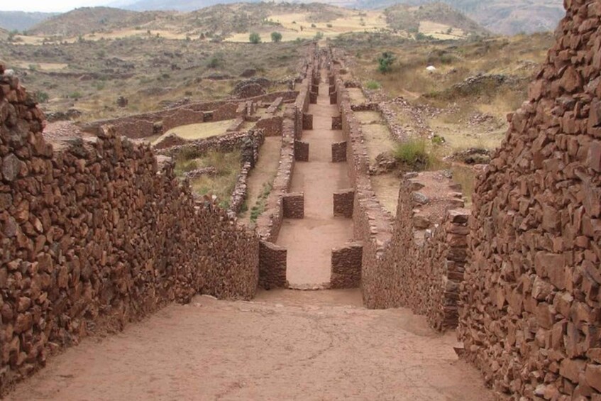 An ancient stone pathway leading through a dry, hilly landscape. 1