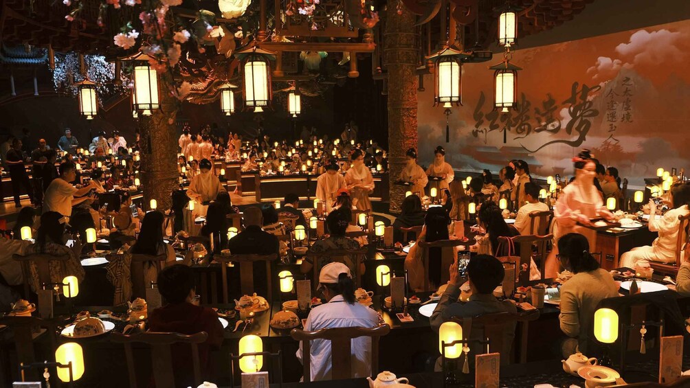 A traditional Chinese restaurant with patrons dining and waitstaff serving. 2