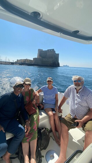 A group of people on a boat with a castle in the background. 2