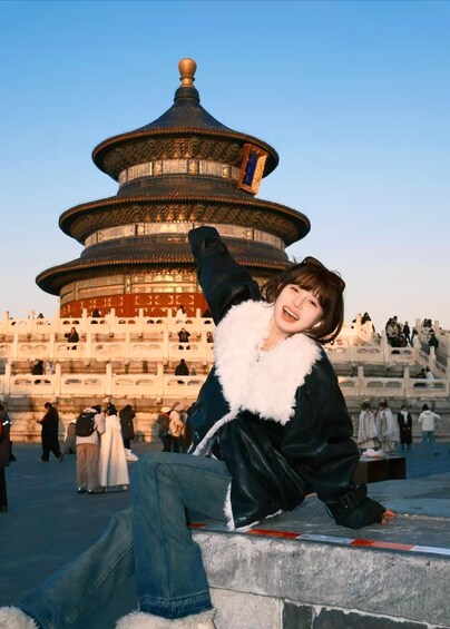 Une personne assise sur une corniche, avec une pagode chinoise traditionnelle en arrière-plan. 1