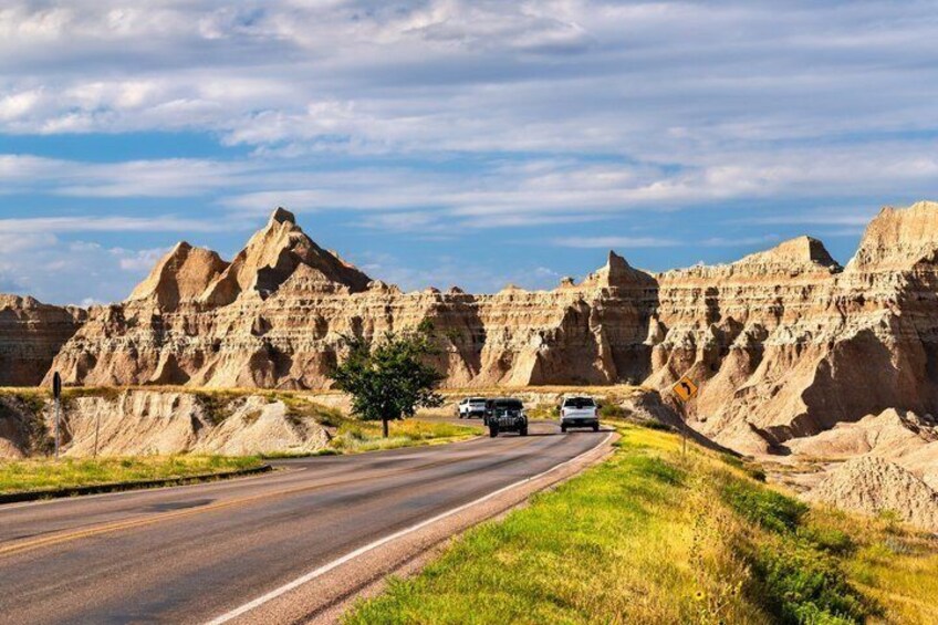 A road with vehicles, surrounded by a rugged landscape with prominent rock formations. 2