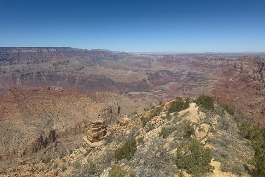 A canyon landscape with layered rock formations and sparse vegetation. 2