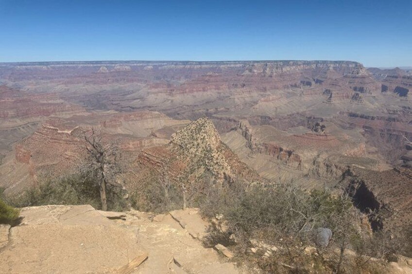 A vast canyon landscape with layered rock formations and sparse vegetation. 5