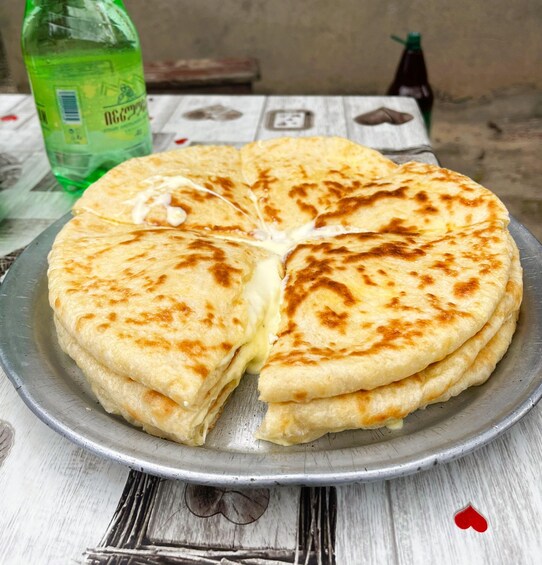 A stack of flatbreads on a metal plate. 4