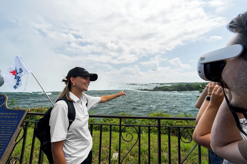 A person pointing towards a body of water with a flag in the background. 4