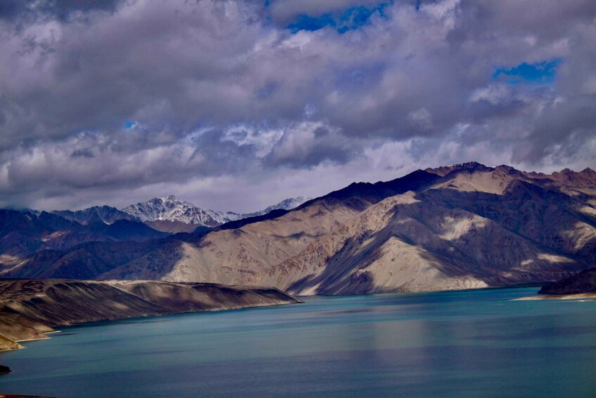 A mountainous landscape with a calm lake and snow-capped peaks. 1