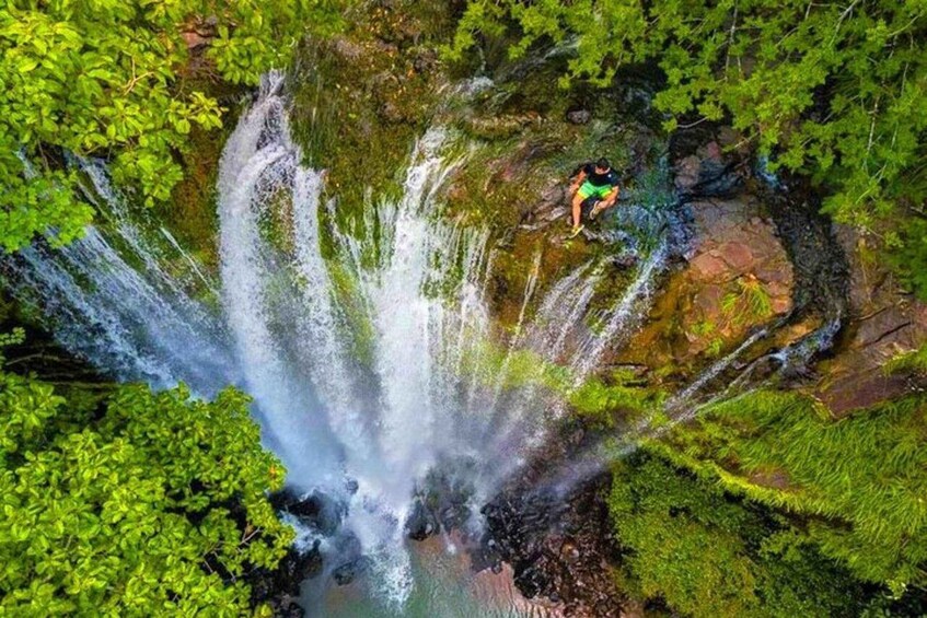 A waterfall cascading over rocks in a lush green forest. 2