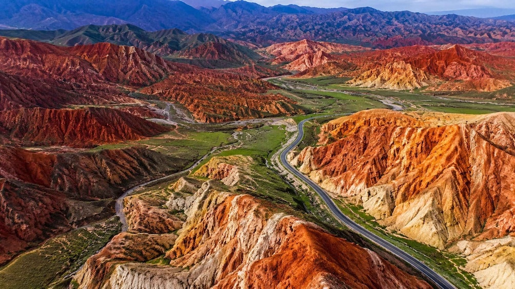A winding road through a colorful mountain range with a valley in the center. 2