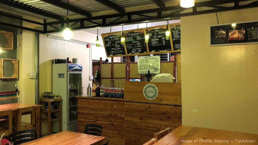 A rustic restaurant interior with wooden tables and a chalkboard menu. 2