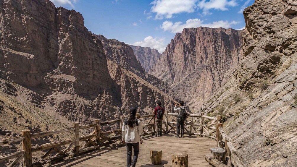 A wooden boardwalk in a canyon with hikers. 5