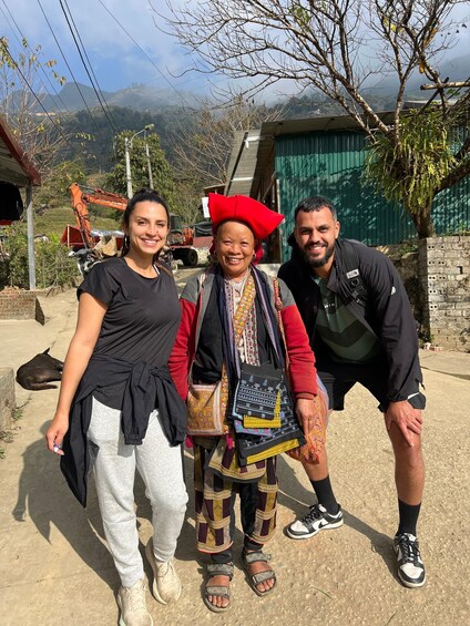 Three people standing outdoors with a mountainous background. 2