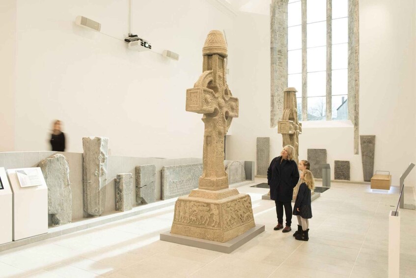 A museum interior with stone sculptures and a large central pillar. 1