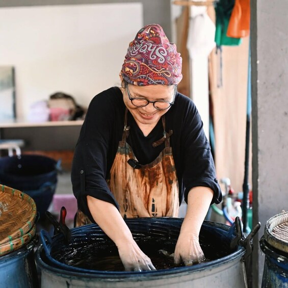 A person washing clothes in a large tub. 5