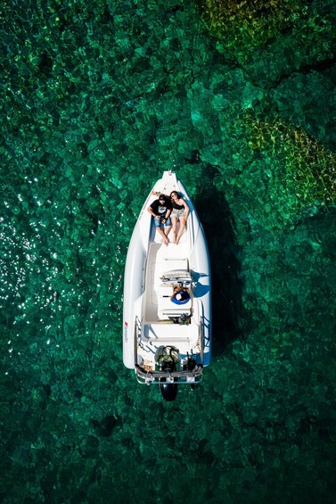 A boat on clear, shallow water with a rocky bottom. 1