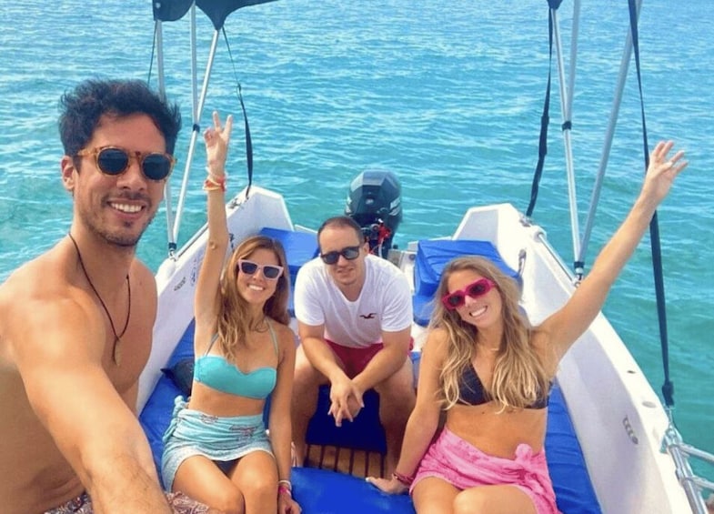 A group of people on a boat with clear blue water in the background. 2