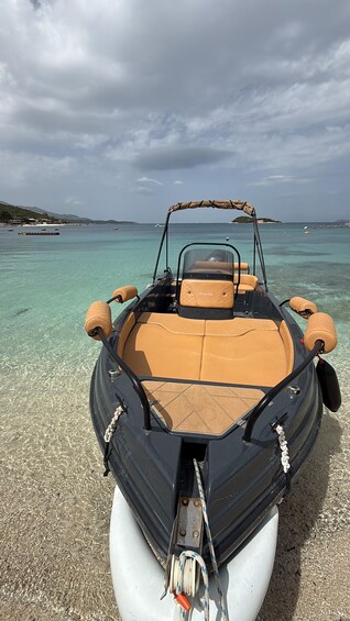 A boat with a canopy, beige cushioned seats, and a rope tied to the front. 2