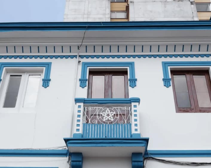 A building with blue trim and a balcony with a star design. 5