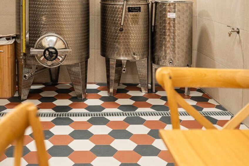 A kitchen with stainless steel appliances, a checkered floor, and wooden chairs. 3
