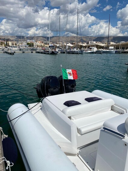 A marina with boats, a flag, and a mountainous backdrop. 4