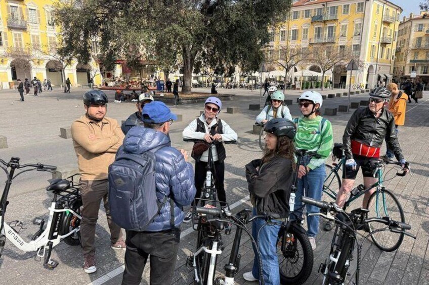A group of people with bicycles in an urban square. 3