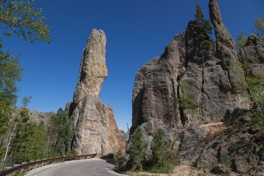 A winding road with a prominent rock formation on the right. 4