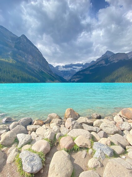 A turquoise lake surrounded by mountains and rocky shores. 1