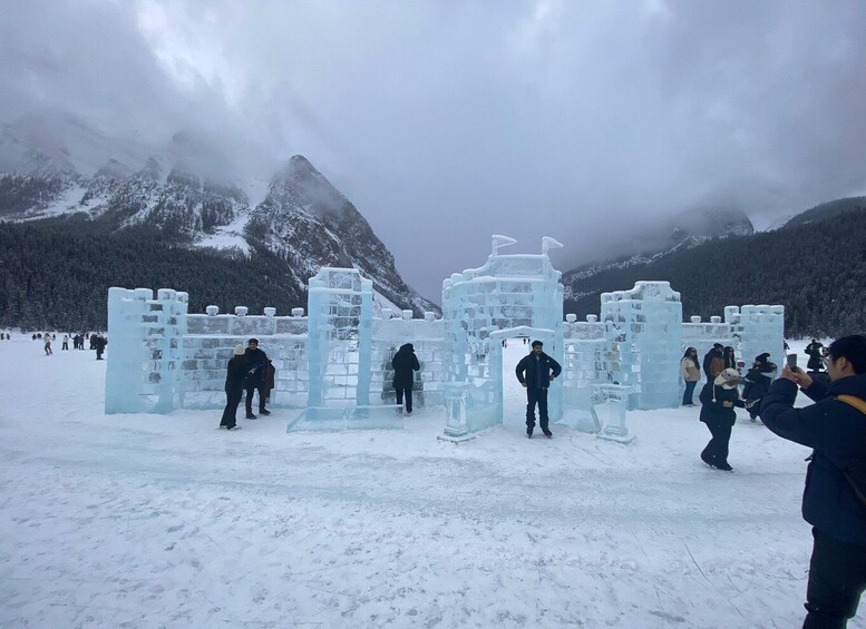 An ice sculpture resembling a castle in a snowy mountainous area. 4