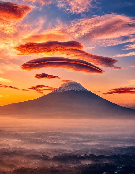 A mountain with a snow-capped peak, surrounded by a valley with a misty atmosphere. 4