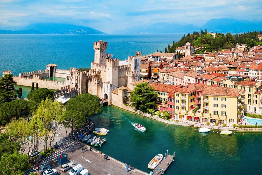 A coastal town with historic architecture, a castle, and a marina. 3