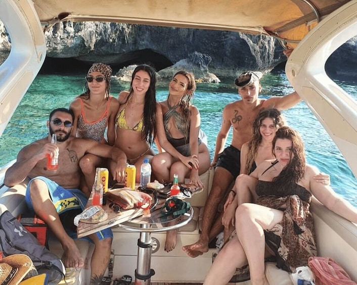 A group of people on a boat with a rocky coastline in the background. 3