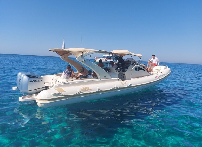 A white motorboat with a Honda engine on clear blue water. 4