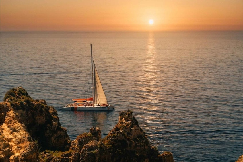 A sailboat on calm waters with a sunset in the background. 3